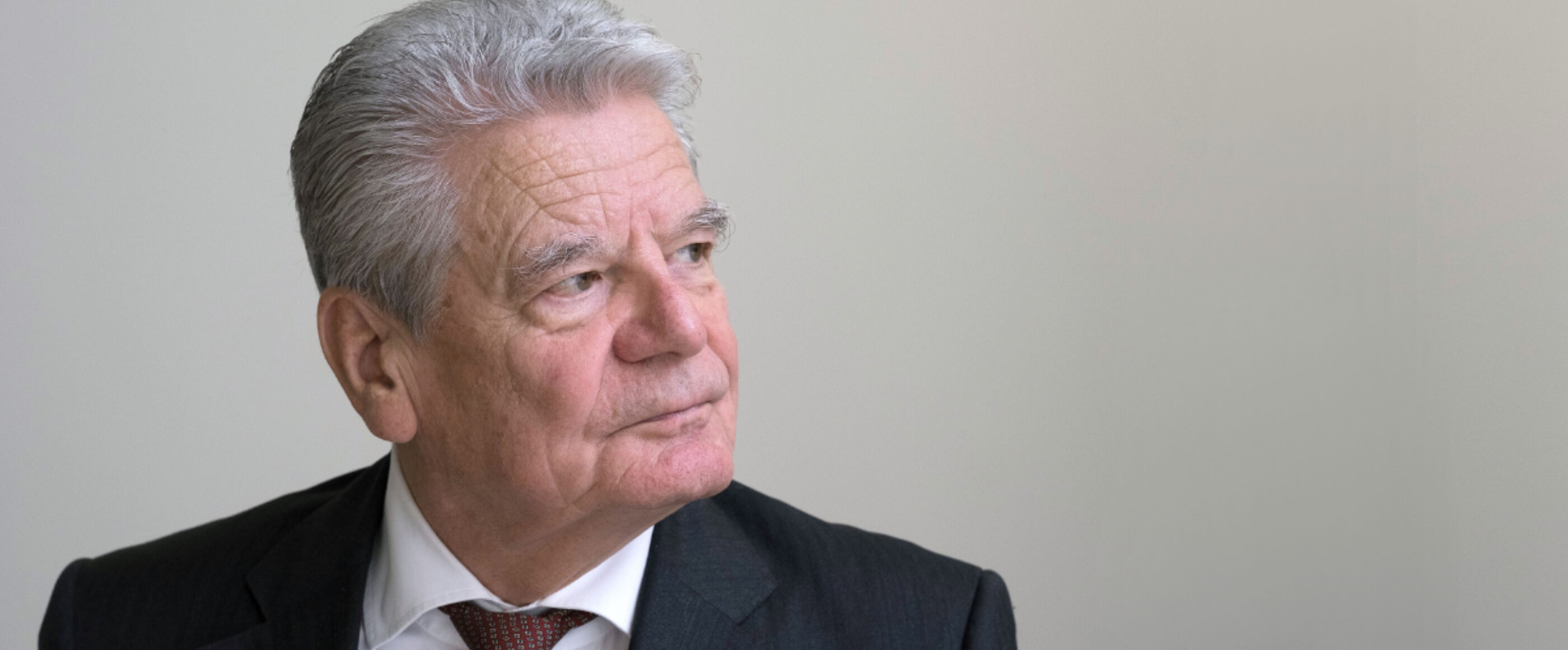 Ein älter Mann in schwarzem Anzug und mit grauen Haaren schaut nach rechts. Das Bild zeigt den früheren Bundespräsidenten Joachim Gauck.