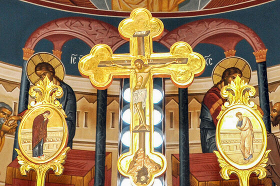 Ein goldenes orthodoxes Kreuz über einem Altar.