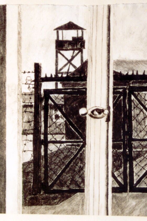 Ein schwarz-weiß Bild zeigt den Blick durch einen Fensterrahmen auf ein Gittertor, Stacheldraht und einen Wachturm.
