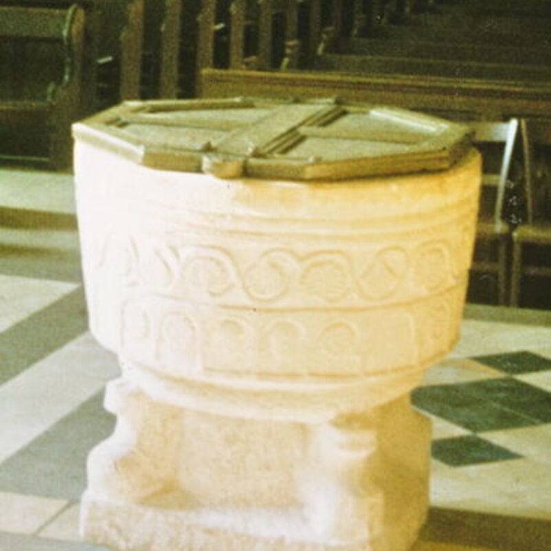 Das Bild zeigt einen steinernen Taufstein, dessen Becken in der Mitte geteilt ist.