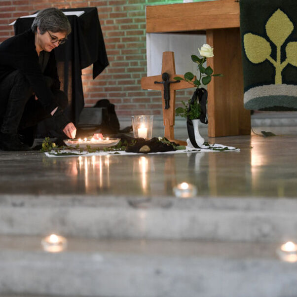 Pastorin Franziska Oberheide entzündet eine Kerze zum Gedenken im Innenraum der Corvinus-Kirche in Wunstorf