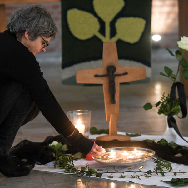 Pastorin Franziska Oberheide entzündet eine Kerze zum Gedenken im Innenraum der Corvinus-Kirche in Wunstorf